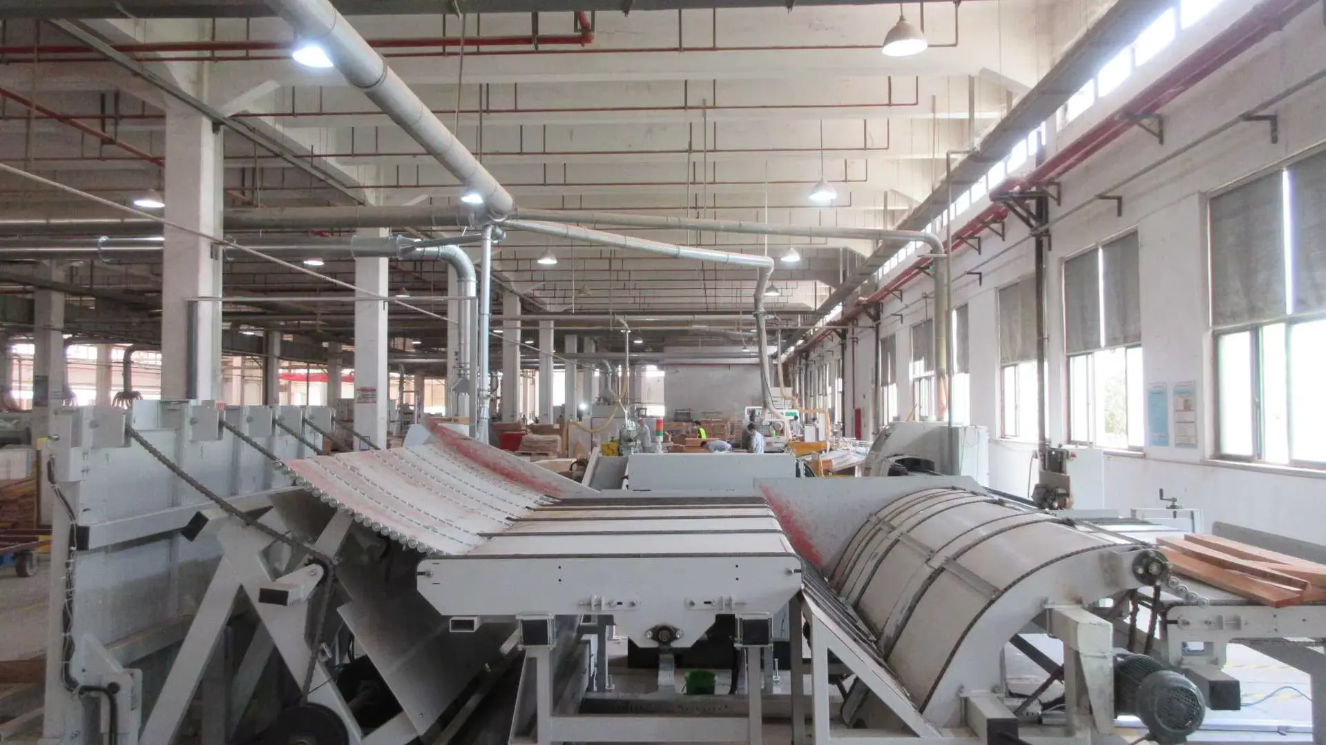 Automatic wood beam loader machine processing stacked timber in wooden nursery furniture factory. Automatic wood beam loader machine processing stacked timber in wooden nursery furniture factory.