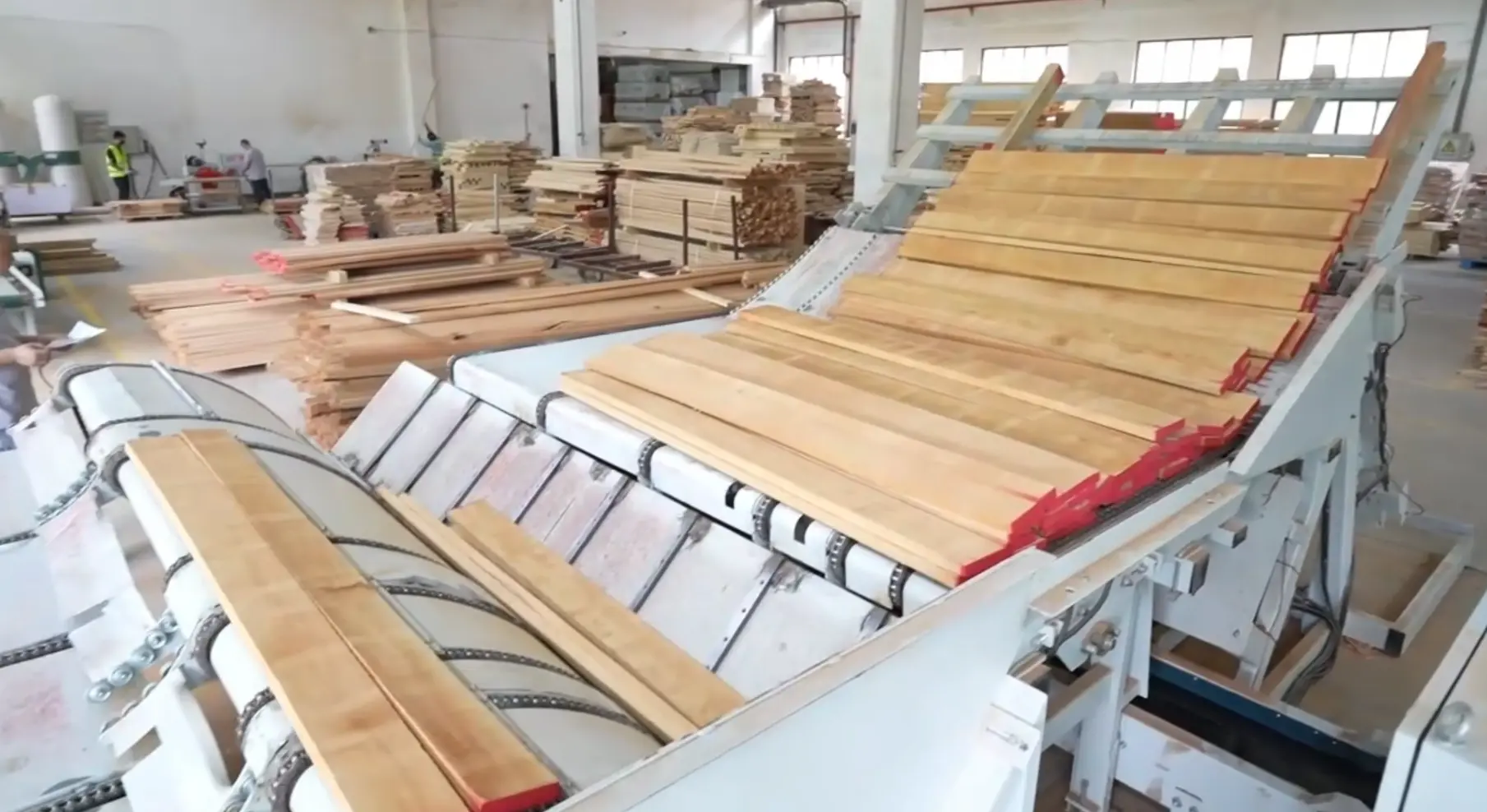 Automatic wood beam loader machine processing stacked timber in wooden nursery furniture factory. Automatic wood beam loader machine processing stacked timber in wooden nursery furniture factory.